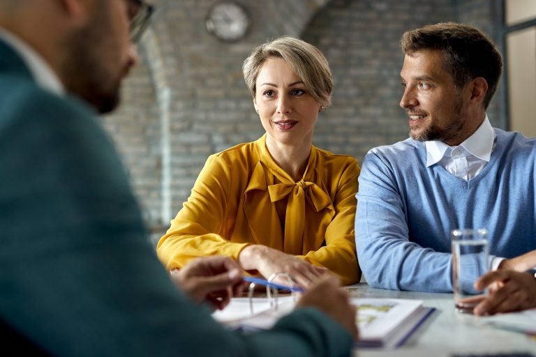 Smiling couple having consultations with their financial advisor in the office.