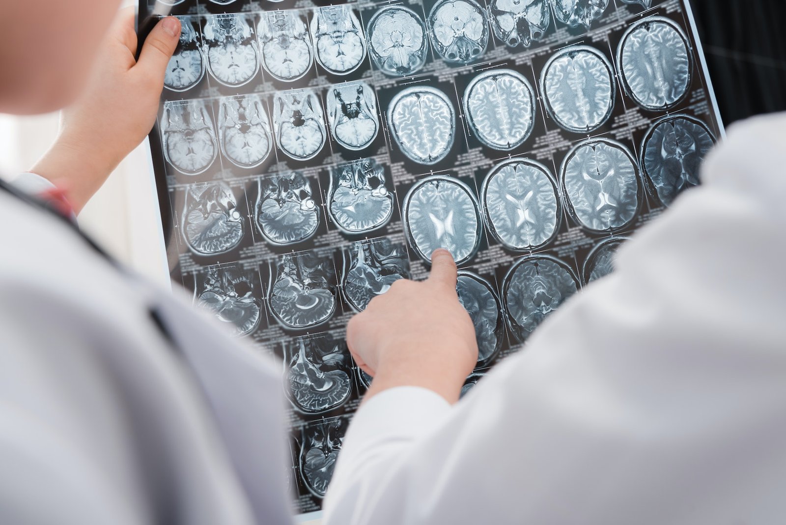 Partial view of kids doctors in medical uniform examining x-ray image